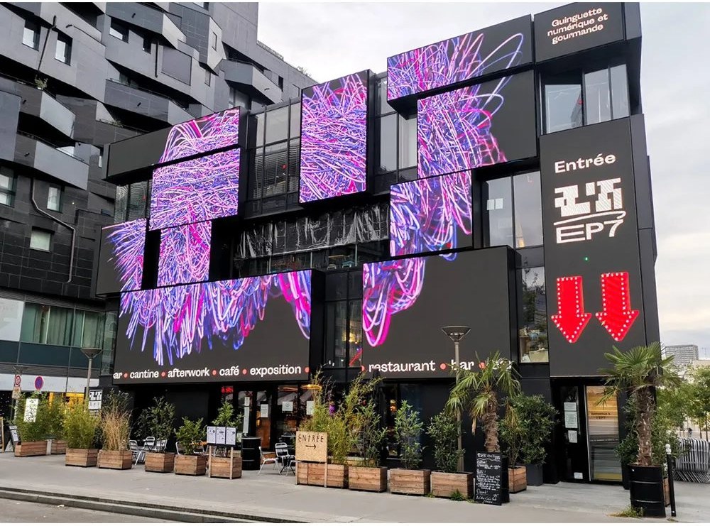 Outdoor facade digital billboard showing bright advertising content on a building exterior